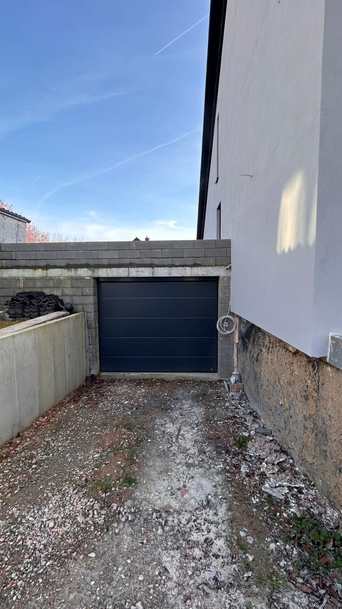 Modernes Garagentor mit glatter Oberfläche in Anthrazitgrau bei Einfamilienhaus